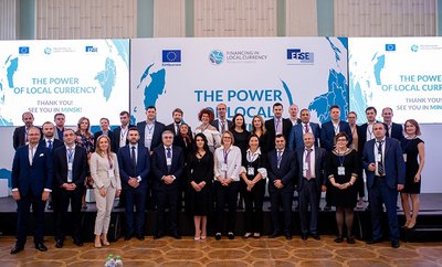 A crowd of participants stands on the stage at the Power of Local Currency event in Moldova